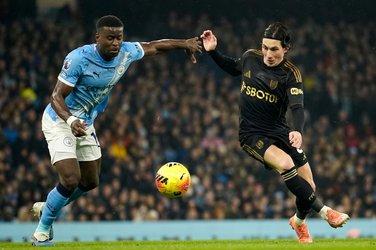 Manchester City's Marc Guehi, left, and Fulham's Harry Wilson challenge for the ball during the English Premier League soccer match between Manchester City and Fulham in Manchester, England, Wednesday, Feb. 11, 2026. (AP Photo/Dave Thompson)