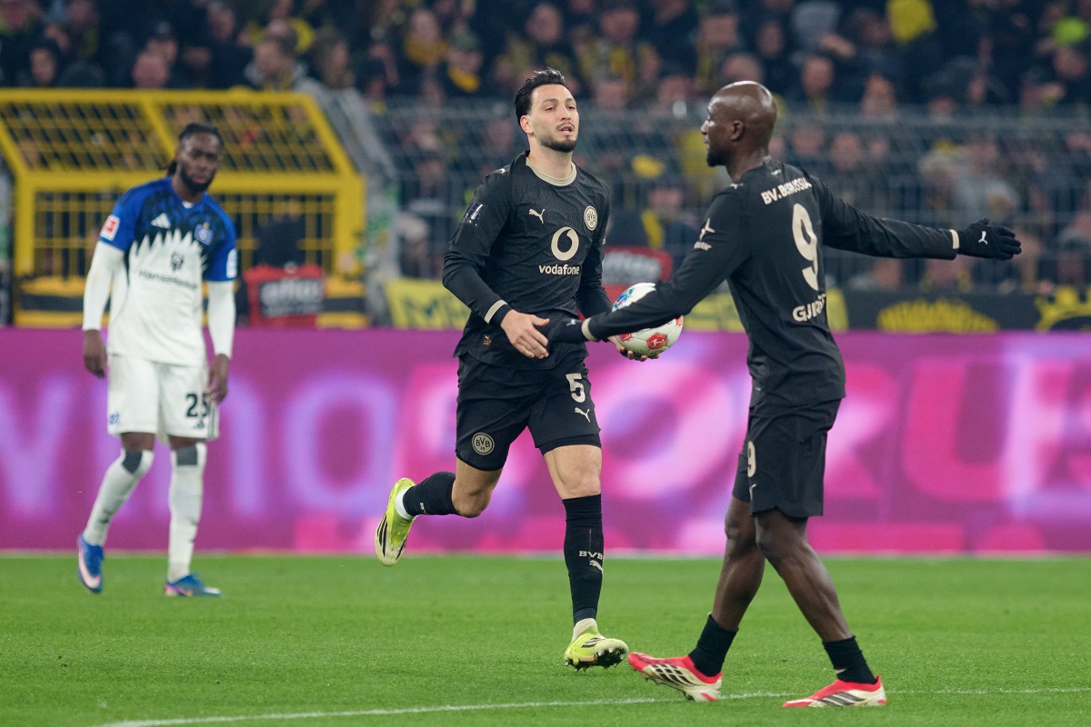 Dortmund's Ramy Bensebaini, center, celebrates after scoring a penalty goal during the German Bundesliga soccer match between Borussia Dortmund and Hamburger SV in Dortmund, Germany, Saturday, March 21, 2026. (Bernd Thissen/dpa via AP)