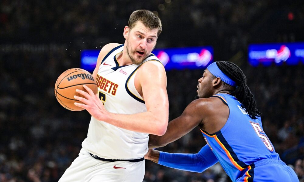 Denver Nuggets center Nikola Jokić, left, drives against Oklahoma City Thunder guard Luguentz Dort (5) during the first half of an NBA basketball game, Monday, Mar. 9, 2026, in Oklahoma City. (AP Photo/Gerald Leong)