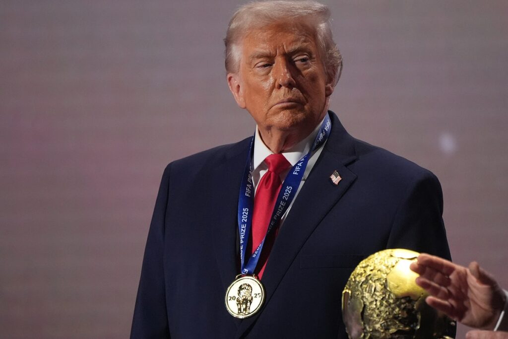 FILE - President Donald Trump stands on stage next to the FIFA World Cup after receiving the FIFA Peace Prize during the draw for the 2026 soccer World Cup at the Kennedy Center in Washington, Dec. 5, 2025. (AP Photo/Jacquelyn Martin, File)