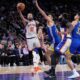 New York Knicks' Jalen Brunson (11), left, drives to the basket past Golden State Warriors defenders during the second half of an NBA basketball game Sunday, March 15, 2026, in New York. (AP Photo/Seth Wenig)