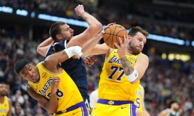 Los Angeles Lakers guard Luka Dončić, right, pulls in a rebound as forward Rui Hachimura, left, boxes out Denver Nuggets center Nikola Jokić in the second half of an NBA basketball game Thursday, March 5, 2026, in Denver. (AP Photo/David Zalubowski)