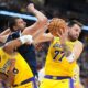 Los Angeles Lakers guard Luka Dončić, right, pulls in a rebound as forward Rui Hachimura, left, boxes out Denver Nuggets center Nikola Jokić in the second half of an NBA basketball game Thursday, March 5, 2026, in Denver. (AP Photo/David Zalubowski)