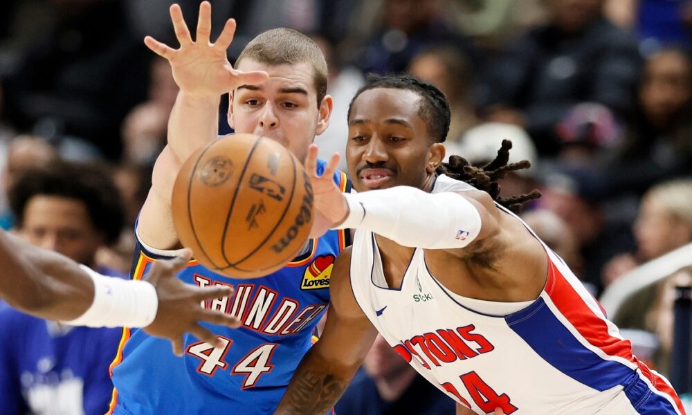 Oklahoma City Thunder guard Nikola Topic (44) and Detroit Pistons guard Daniss Jenkins scramble for a loose ball during the second half of an NBA basketball game, Wednesday, Feb. 25, 2026, in Detroit. (AP Photo/Duane Burleson)
