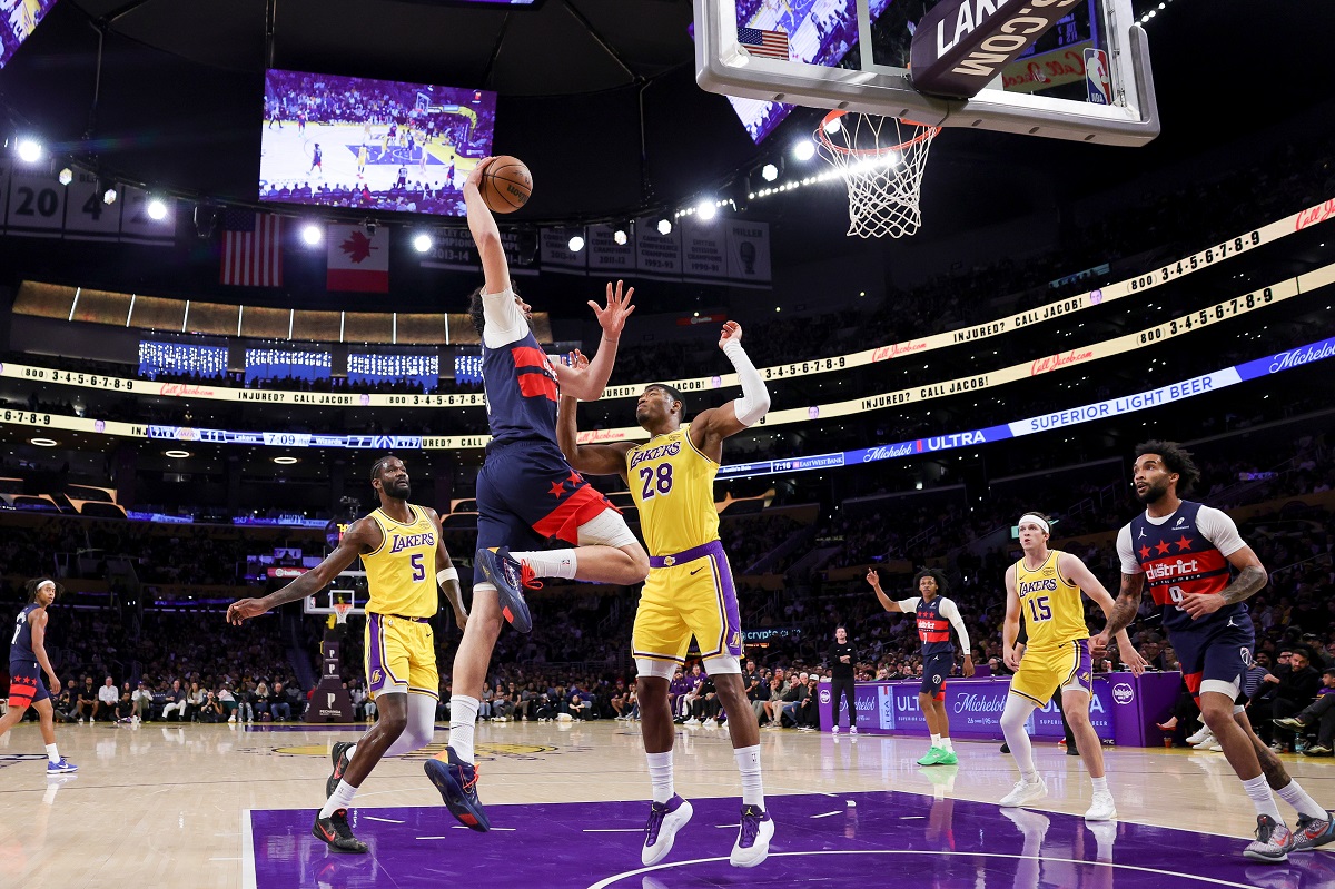 Washington Wizards forward Tristan Vukcevic, second from left, dunks against Los Angeles Lakers center Deandre Ayton, left, and Los Angeles Lakers forward Rui Hachimura, center, during the first half of an NBA basketball game Monday, March 30, 2026, in Los Angeles. (AP Photo/Ryan Sun)
