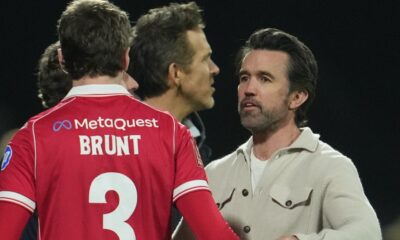 Actors and Wrexham owners Ryan Reynolds, center, and Rob McElhenney stand on the pitch after the fifth round FA Cup soccer match between Wrexham and Chelsea in Wrexham, Wales, Saturday, March 7, 2026. (AP Photo/Jon Super)