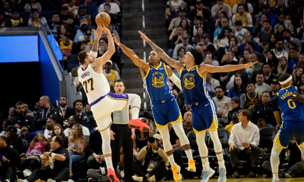 Los Angeles Lakers guard Luka Doncic (77) takes a stepback jumper as Golden State Warriors center-forward Al Horford (20) and forward Gui Santos (15) defend during the second quarter of their NBA basketball game in San Francisco, Saturday, Feb. 28, 2026. (Stephen Lam/San Francisco Chronicle via AP)