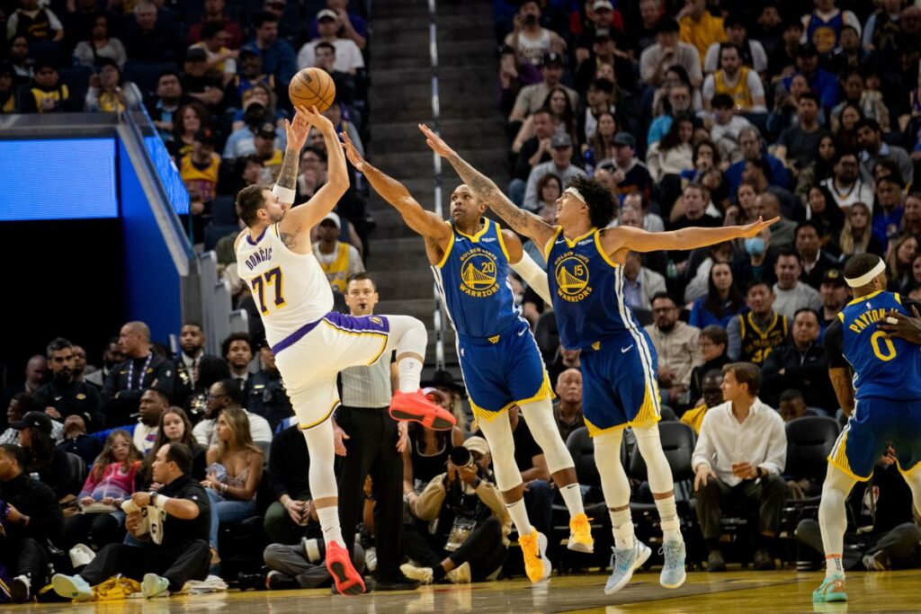 Los Angeles Lakers guard Luka Doncic (77) takes a stepback jumper as Golden State Warriors center-forward Al Horford (20) and forward Gui Santos (15) defend during the second quarter of their NBA basketball game in San Francisco, Saturday, Feb. 28, 2026. (Stephen Lam/San Francisco Chronicle via AP)