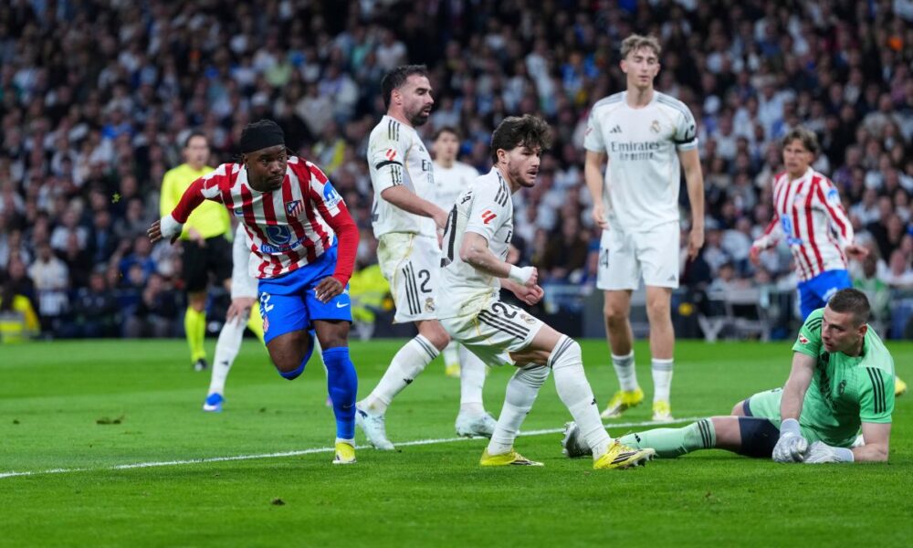 Atletico Madrid's Ademola Lookman, left, celebrates after scoring the opening goal past Real Madrid's goalkeeper Andriy Lunin, right, during the Spanish La Liga soccer match between Real Madrid and Atletico Madrid in Madrid, Spain, Sunday, March 22, 2026. (AP Photo/Manu Fernandez)