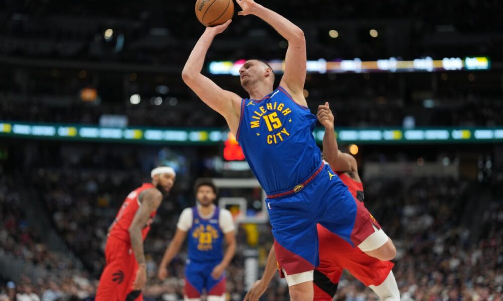Denver Nuggets center Nikola Jokic, front, is fouled as he goes up for a shot by Toronto Raptors forward Scottie Barnes, not visible, in the first half of an NBA basketball game Friday, March 20, 2026, in Denver. (AP Photo/David Zalubowski)