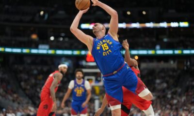 Denver Nuggets center Nikola Jokic, front, is fouled as he goes up for a shot by Toronto Raptors forward Scottie Barnes, not visible, in the first half of an NBA basketball game Friday, March 20, 2026, in Denver. (AP Photo/David Zalubowski)