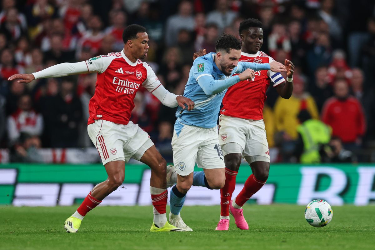Arsenal's Gabriel, left, and Bukayo Saka, challenge Manchester City's Rayan Cherki during the English League Cup final soccer match between Arsenal and Manchester City in London, Sunday, March 22, 2026. (AP Photo/Richard Pelham)