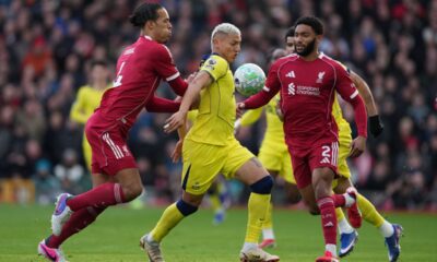 Liverpool's Virgil van Dijk, left, and Tottenham's Richarlison fight for the ball during the Premier League soccer match between Liverpool and Tottenham in Liverpool, England, Sunday, March 15, 2026. (AP Photo/Jon Super)