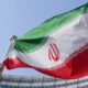 FILE - The Iranian national flag flies during a special session of an IAEA Board of Governors meeting in Vienna, Austria, March 2, 2026. (AP Photo/Heinz-Peter Bader, file)