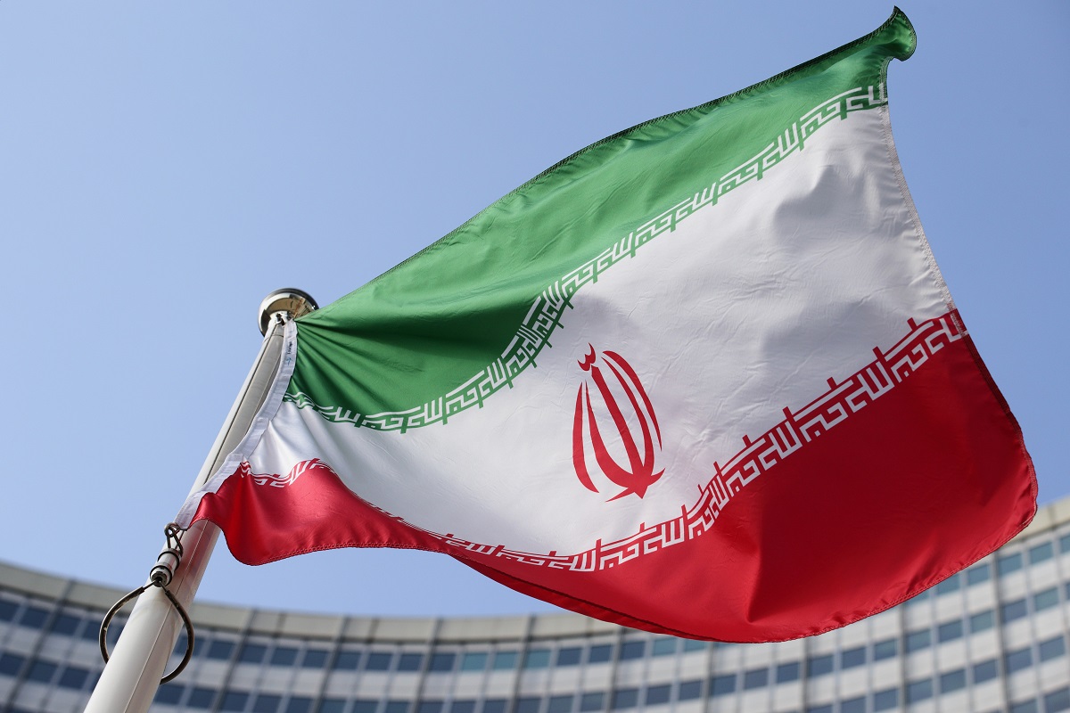 FILE - The Iranian national flag flies during a special session of an IAEA Board of Governors meeting in Vienna, Austria, March 2, 2026. (AP Photo/Heinz-Peter Bader, file)