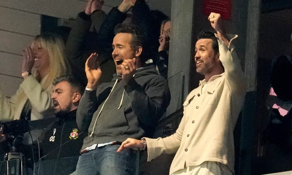 Wrexham co-owners Rob Mac, right, and Ryan Reynolds celebrate after VAR ruled Wrexham's goal onside during the fifth round FA Cup soccer match between Wrexham and Chelsea in Wrexham, Wales, Saturday, March 7, 2026. (Nick Potts/PA via AP)