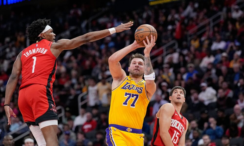 Los Angeles Lakers' Luka Doncic (77) shoots as Houston Rockets' Amen Thompson (1) defends during the first half of an NBA basketball game Monday, March 16, 2026, in Houston. (AP Photo/David J. Phillip)