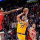 Los Angeles Lakers' Luka Doncic (77) shoots as Houston Rockets' Amen Thompson (1) defends during the first half of an NBA basketball game Monday, March 16, 2026, in Houston. (AP Photo/David J. Phillip)