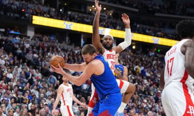 Denver Nuggets center Nikola Jokić, front, pulls in a rebound as Houston Rockets guard Josh Okogie defends in the second half of an NBA basketball game Wednesday, March 11, 2026, in Denver. (AP Photo/David Zalubowski)