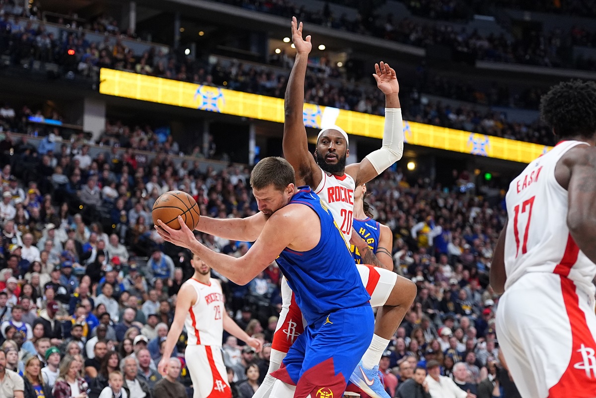 Denver Nuggets center Nikola Jokić, front, pulls in a rebound as Houston Rockets guard Josh Okogie defends in the second half of an NBA basketball game Wednesday, March 11, 2026, in Denver. (AP Photo/David Zalubowski)