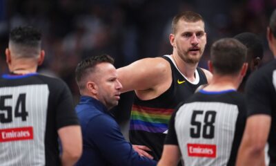 Denver Nuggets center Nikola Jokić, back right, argues for a call after being hit in the nose as assistant coach J.J. Barea, back left, intercedes with referees Ray Acosta, front left, and Josh Tiven in the first half of an NBA basketball game against the San Antonio Spurs, Saturday, April 4, 2026, in Denver. (AP Photo/David Zalubowski)