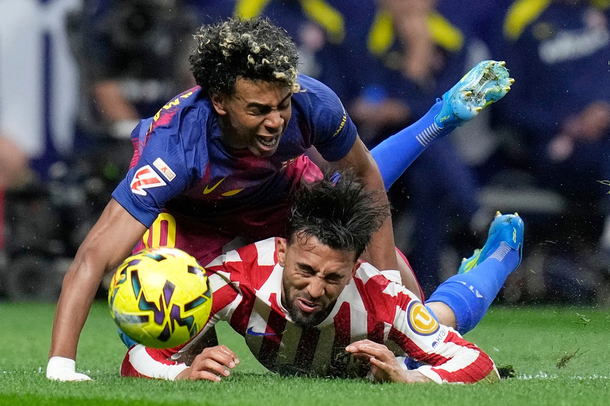 Barcelona's Lamine Yamal, top, is tackled and fouled by Atletico Madrid's Nico Gonzalez, who receives a second yellow card and is then sent off during a La Liga soccer match between Atletico Madrid and Barcelona in Madrid, Spain, Saturday, April 4, 2026. (AP Photo/Bernat Armangue)