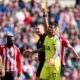 Referee Robert Jones shows Tottenham Hotspur's Cristian Romero a yellow card during the Premier League soccer match between Sunderland and Tottenham Hotspur, in Sunderland, England, Sunday April 12, 2026. (Richard Sellers/PA via AP)