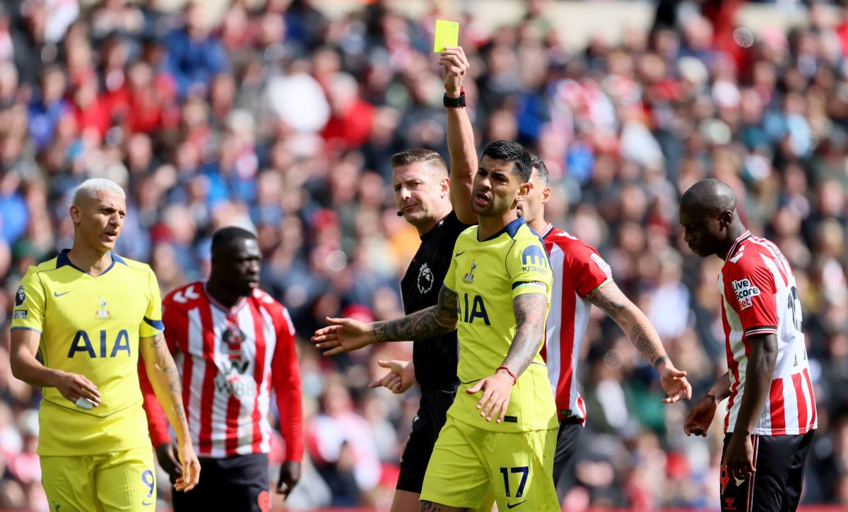 Referee Robert Jones shows Tottenham Hotspur's Cristian Romero a yellow card during the Premier League soccer match between Sunderland and Tottenham Hotspur, in Sunderland, England, Sunday April 12, 2026. (Richard Sellers/PA via AP)