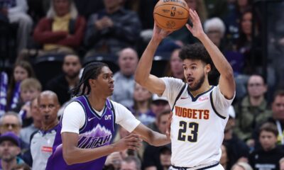Denver Nuggets forward Cameron Johnson (23) looks for a play as Utah Jazz forward Cody Williams defends during the first half of an NBA basketball game, Wednesday, April 1, 2026, in Salt Lake City. (AP Photo/Rob Gray)