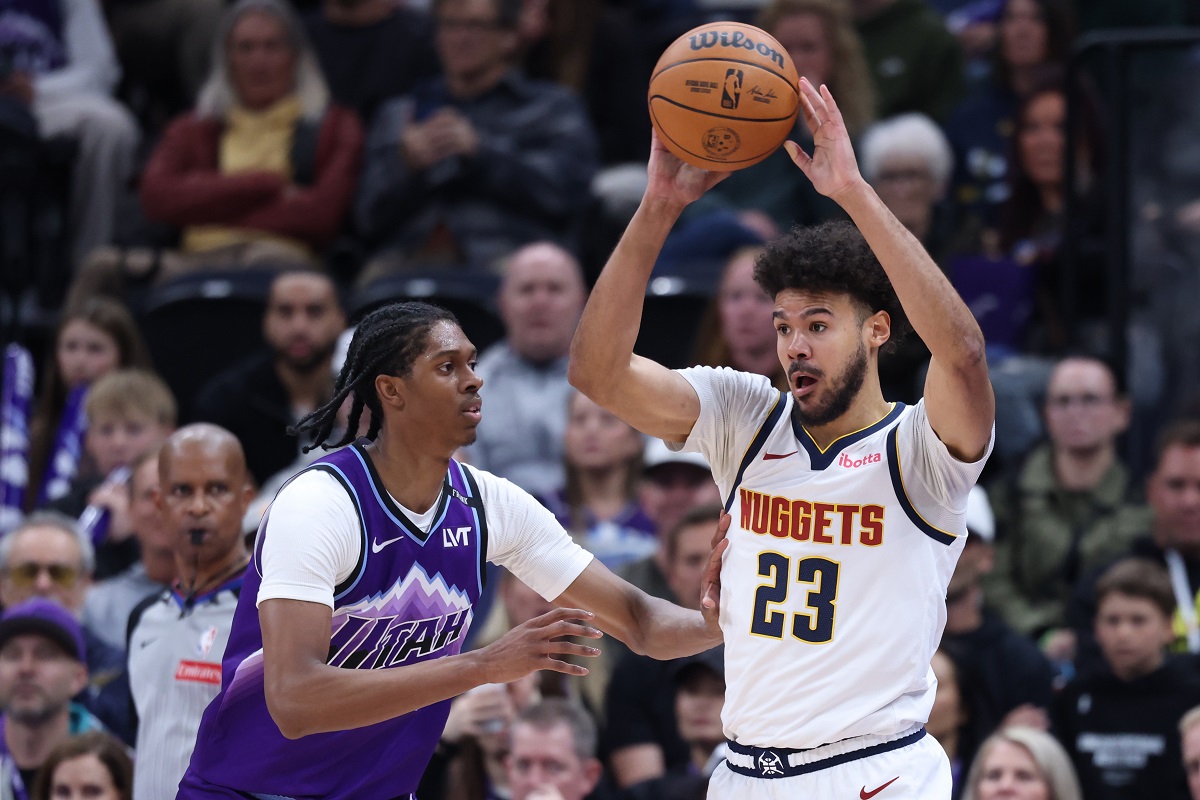 Denver Nuggets forward Cameron Johnson (23) looks for a play as Utah Jazz forward Cody Williams defends during the first half of an NBA basketball game, Wednesday, April 1, 2026, in Salt Lake City. (AP Photo/Rob Gray)