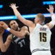 Minnesota Timberwolves center Rudy Gobert (27) handles the ball as Denver Nuggets center Nikola Jokic (15) defends during the second half in Game 3 of a first-round NBA basketball playoff series, Thursday, April 23, 2026, in Minneapolis. (AP Photo/Abbie Parr)