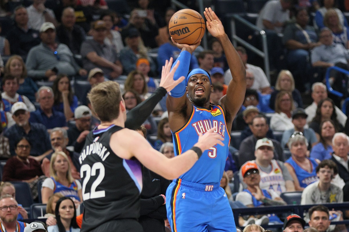 Oklahoma City Thunder guard Luguentz Dort (5) looks to shoot over Utah Jazz forward Kyle Filipowski (22) during the first half of an NBA basketball game Sunday, April 5, 2026, in Oklahoma City. (AP Photo/Nate Billings)
