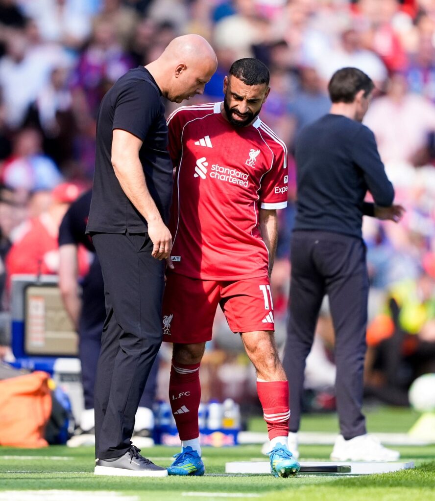 Liverpool's Mohamed Salah grabs at his leg as he speaks with with manager Arne Slot after being substituted during the Premier League soccer match between Liverpool and Crystal Palace, Saturday, April 25, 2026, in Liverpool, England. (Peter Byrne/PA via AP)