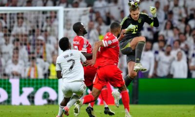 Bayern's goalkeeper Manuel Neuer heads the ball to save before Real Madrid's Vinicius Junior, left, can score during the Champions League quarterfinal first leg soccer match between Real Madrid and Bayern Munich in Madrid, Spain, Tuesday, April 7, 2026. (AP Photo/Jose Breton)