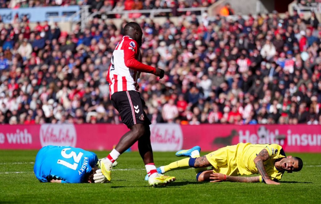 Sunderland's Brian Brobbey, centre, looks on after pushing Tottenham Hotspur's Cristian Romero, right, into Tottenham Hotspur goalkeeper Antonin Kinsky, left, during the Premier League soccer match between Sunderland and Tottenham Hotspur, in Sunderland, England, Sunday April 12, 2026. (Owen Humphreys/PA via AP)