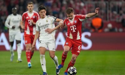 Real Madrid's Arda Guler, left, challenges for the ball with Bayern's Joshua Kimmich during the Champions League quarterfinal second leg soccer match between Bayern Munich and Real Madrid in Munich, Germany, Wednesday, April 15, 2026. (AP Photo/Matthias Schrader)