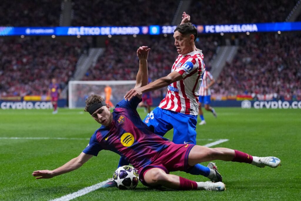 Barcelona's Fermin Lopez, front, and Atletico Madrid's Nahuel Molina challenge for the ball during the Champions League quarterfinal second leg soccer match between Atletico Madrid and Barcelona in Madrid, Spain, Tuesday, April 14, 2026. (AP Photo/Manu Fernandez)