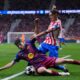 Barcelona's Fermin Lopez, front, and Atletico Madrid's Nahuel Molina challenge for the ball during the Champions League quarterfinal second leg soccer match between Atletico Madrid and Barcelona in Madrid, Spain, Tuesday, April 14, 2026. (AP Photo/Manu Fernandez)