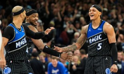 Orlando Magic forward Paolo Banchero (5) celebrates with teammates guard Jalen Suggs, left, and center Wendell Carter Jr. after sinking a 3-point shot against the Detroit Pistons during the closing moments of the second half in Game 3 of a first-round NBA basketball playoff series, Saturday, April 25, 2026, in Orlando, Fla. (AP Photo/John Raoux)