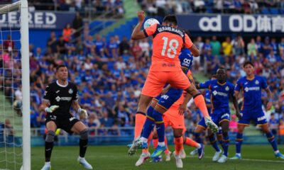Barcelona's Gerard Martin (18) heads the ball in front of Getafe's goalkeeper David Soria during the Spanish La Liga soccer match between Getafe and Barcelona in Getafe, Spain, Saturday, April 25, 2026. (AP Photo/Manu Fernandez)
