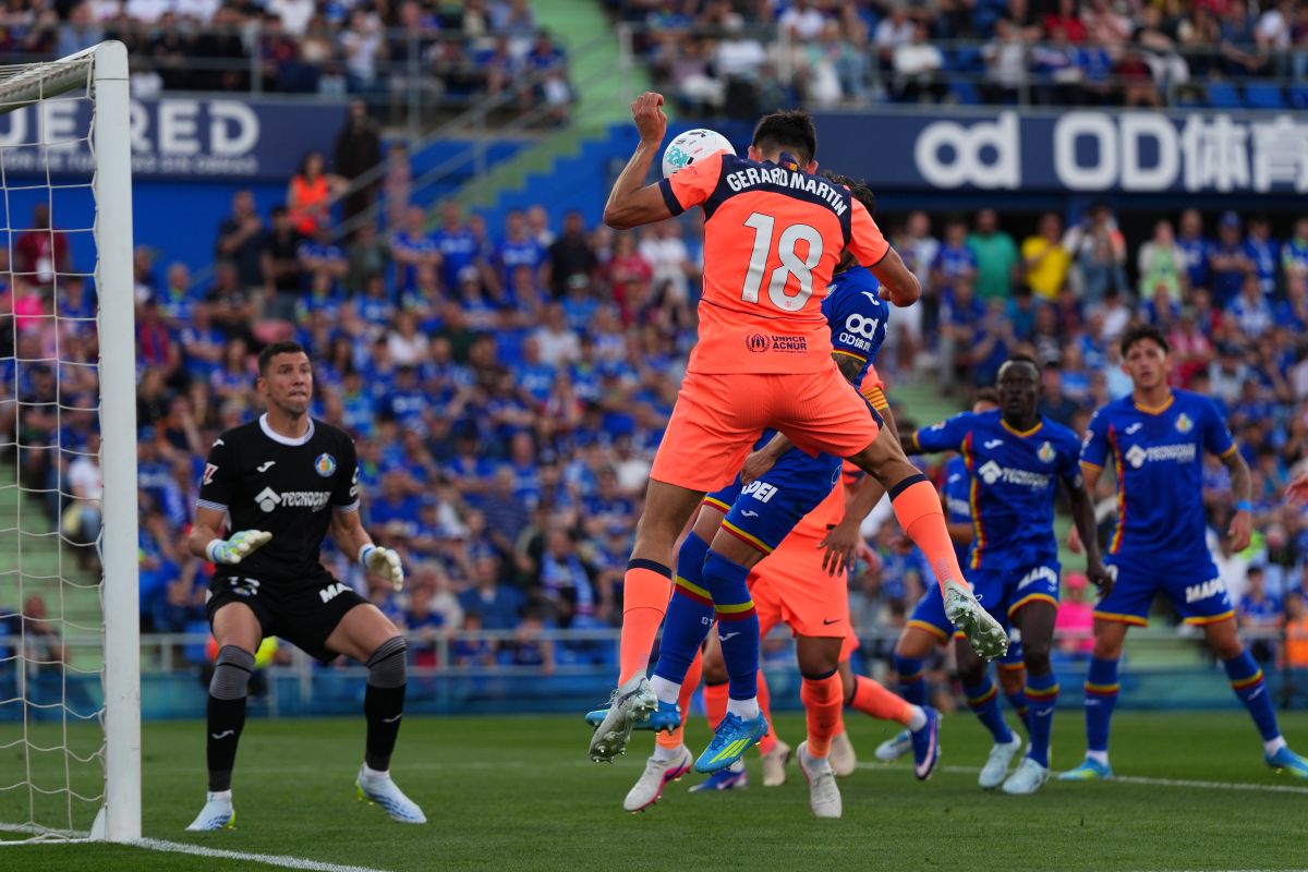 Barcelona's Gerard Martin (18) heads the ball in front of Getafe's goalkeeper David Soria during the Spanish La Liga soccer match between Getafe and Barcelona in Getafe, Spain, Saturday, April 25, 2026. (AP Photo/Manu Fernandez)