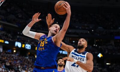 Denver Nuggets center Nikola Jokic (15) pulls down a rebound against Minnesota Timberwolves center Rudy Gobert (27) during the second half in Game 2 of a first-round NBA playoffs basketball series Monday, April 20, 2026, in Denver. (AP Photo/Jack Dempsey)