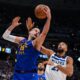Denver Nuggets center Nikola Jokic (15) pulls down a rebound against Minnesota Timberwolves center Rudy Gobert (27) during the second half in Game 2 of a first-round NBA playoffs basketball series Monday, April 20, 2026, in Denver. (AP Photo/Jack Dempsey)