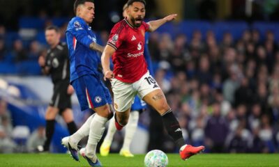 Manchester United's Matheus Cunha, center, and Chelsea's Enzo Fernandez challenge for the ball during the English Premier League soccer match between Chelsea and Manchester United in London, Saturday, April 18, 2026. (AP Photo/Kirsty Wigglesworth)