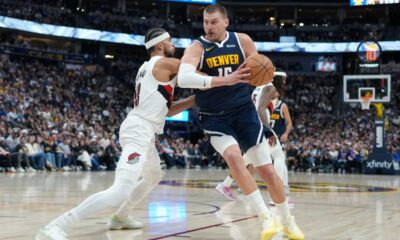 Denver Nuggets center Nikola Jokić, right, drives to the rim as Portland Trail Blazers forward Toumani Camara defends in the second half of an NBA basketball game Monday, April 6, 2026, in Denver. (AP Photo/David Zalubowski)