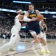 Denver Nuggets center Nikola Jokić, right, drives to the rim as Portland Trail Blazers forward Toumani Camara defends in the second half of an NBA basketball game Monday, April 6, 2026, in Denver. (AP Photo/David Zalubowski)