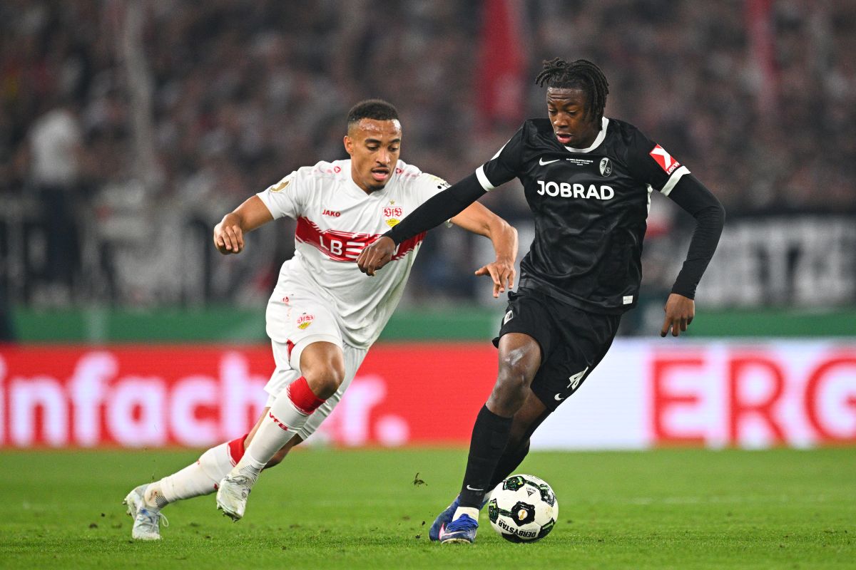 Freiburg's Johan Manzambi, right, turns away Stuttgart's Jamie Leweling during a German Cup semifinal soccer match between VfB Stuttgart and SC Freiburg, Thursday, April 23, 2026, in Stuttgart, Germany. (Tom Weller/dpa via AP)