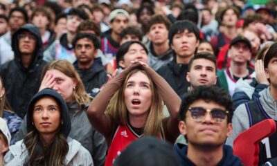 Fans react as they watch a broadcast as the Toronto Raptors play the Cleveland Cavaliers Game 1 in a first-round NBA playoffs basketball series outside Scotiabank Arena in Toronto, Saturday, April 18, 2026. (Sammy Kogan/The Canadian Press via AP)