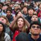 Fans react as they watch a broadcast as the Toronto Raptors play the Cleveland Cavaliers Game 1 in a first-round NBA playoffs basketball series outside Scotiabank Arena in Toronto, Saturday, April 18, 2026. (Sammy Kogan/The Canadian Press via AP)