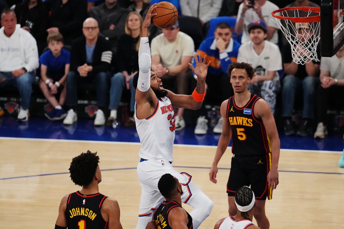New York Knicks' Karl-Anthony Towns (32) drives past Atlanta Hawks' Dyson Daniels (5) during the first half in Game 1 of a first-round NBA playoffs basketball series, Saturday, April 18, 2026, in New York. (AP Photo/Frank Franklin II)
